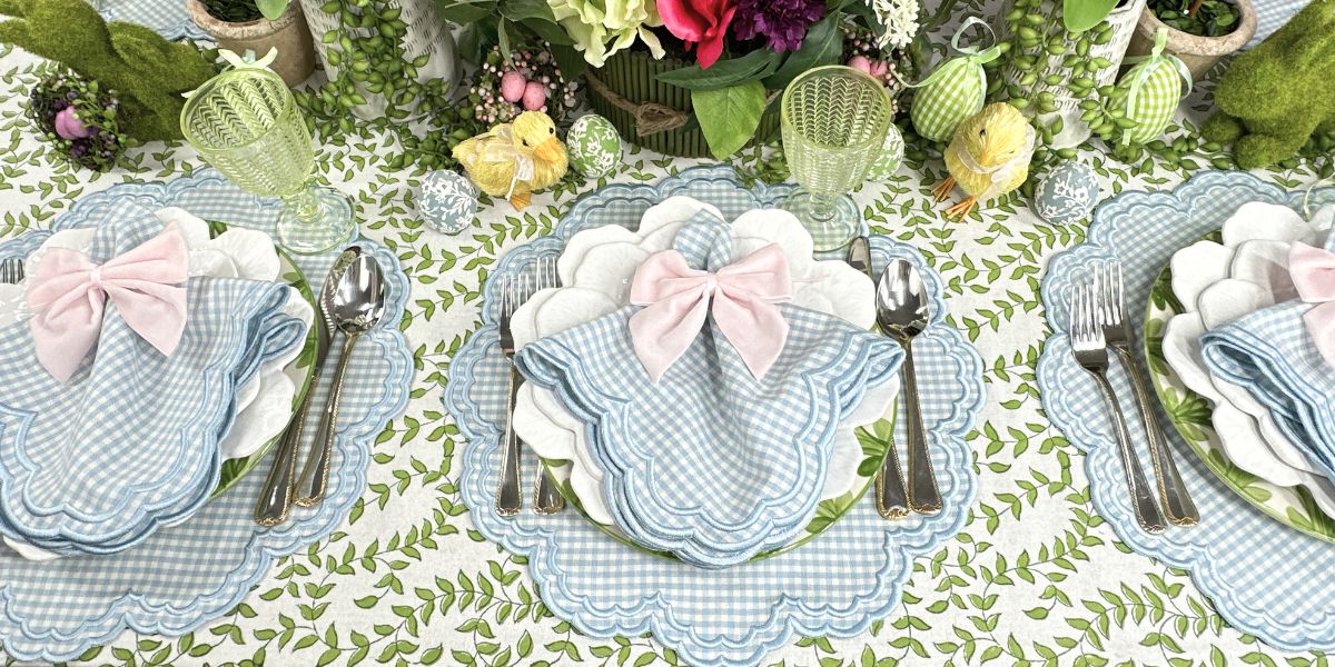 Blue gingham placemats and napkins on green leaves tablecloth