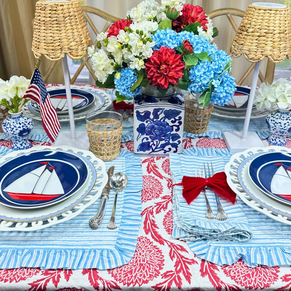 Red flower tablecloth with blue ruffle placemat and napkins